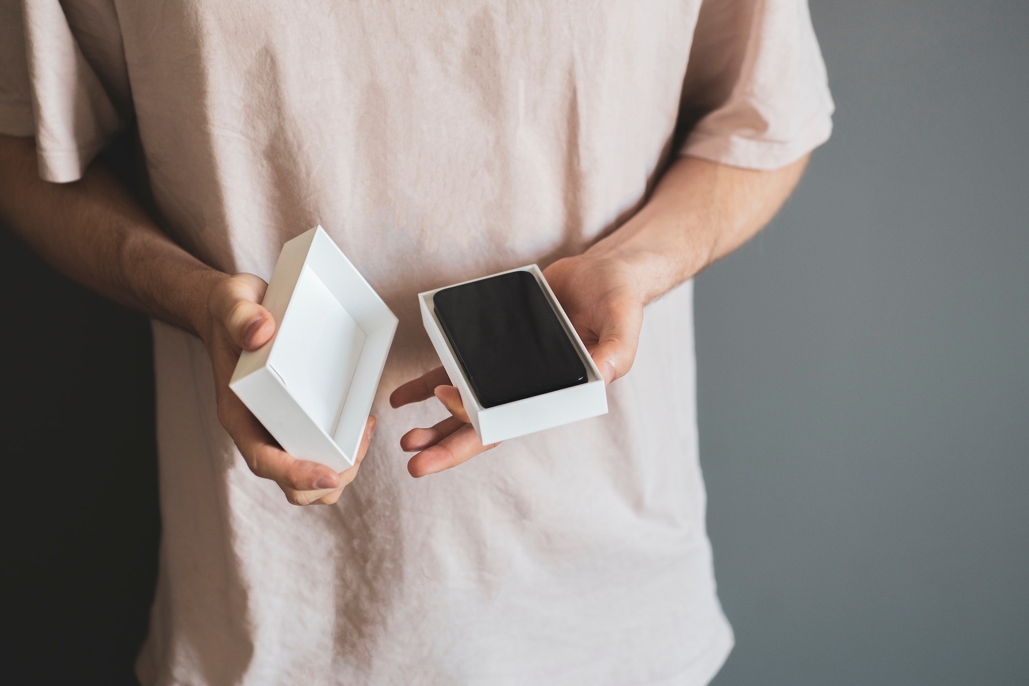 a person holds the new smartphone box or case and unpack it, holiday surprise present concept